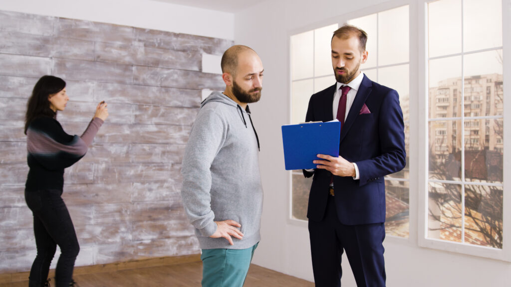 Real estate agent in business suit describes apartment to client